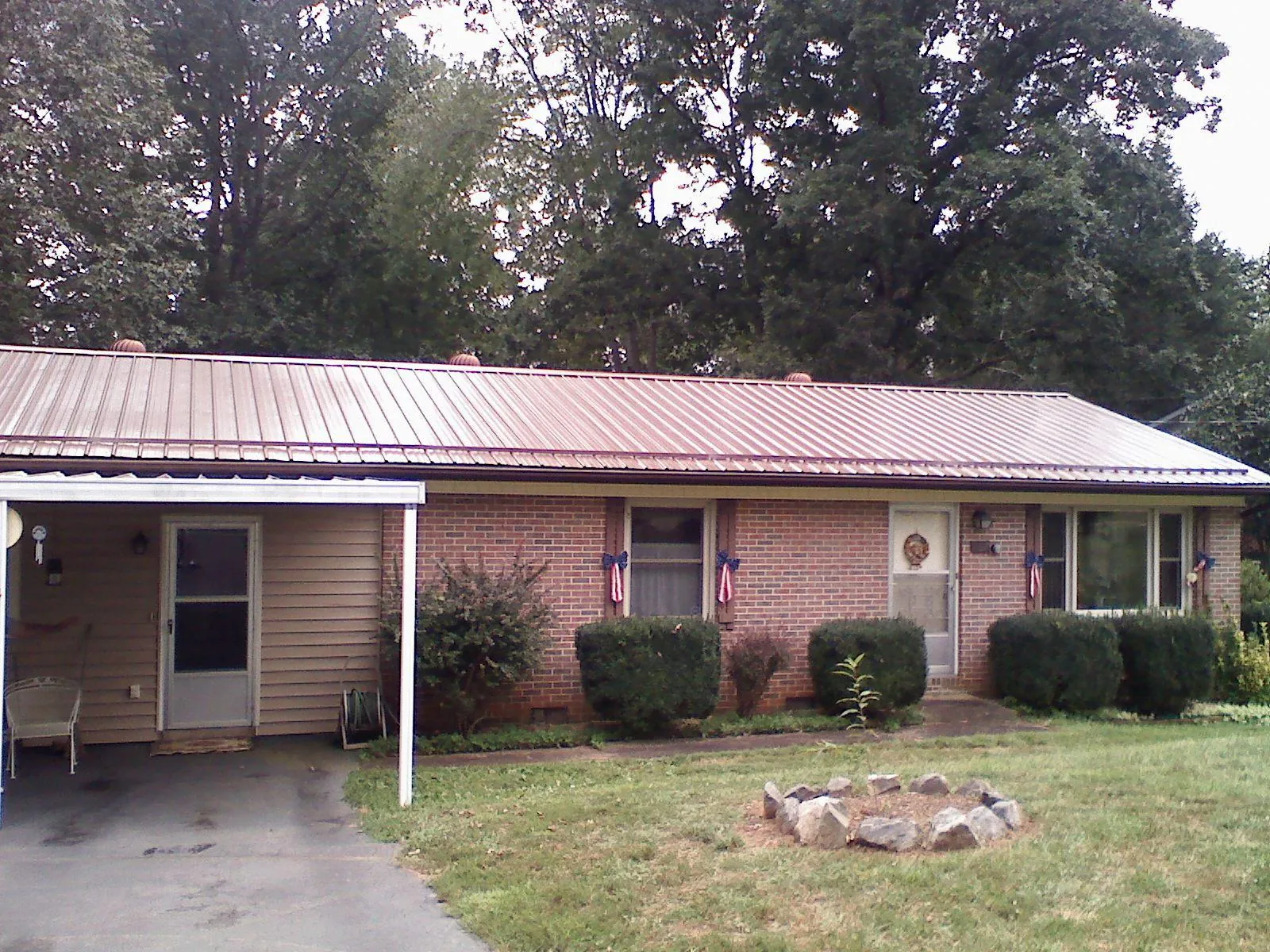 Bronze metal roof and carport on a brick ranch home — Roof Repair work by our crew in Garland